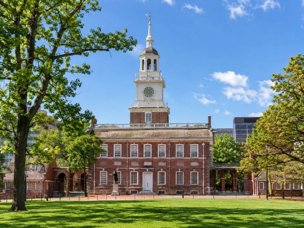 Die rote Backsteinfassade und der Glockenturm von Independence Hall, vom Rasen aus gesehen
